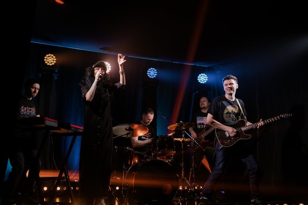 Dynamic live music performance featuring a rock band with singer and instruments on stage.